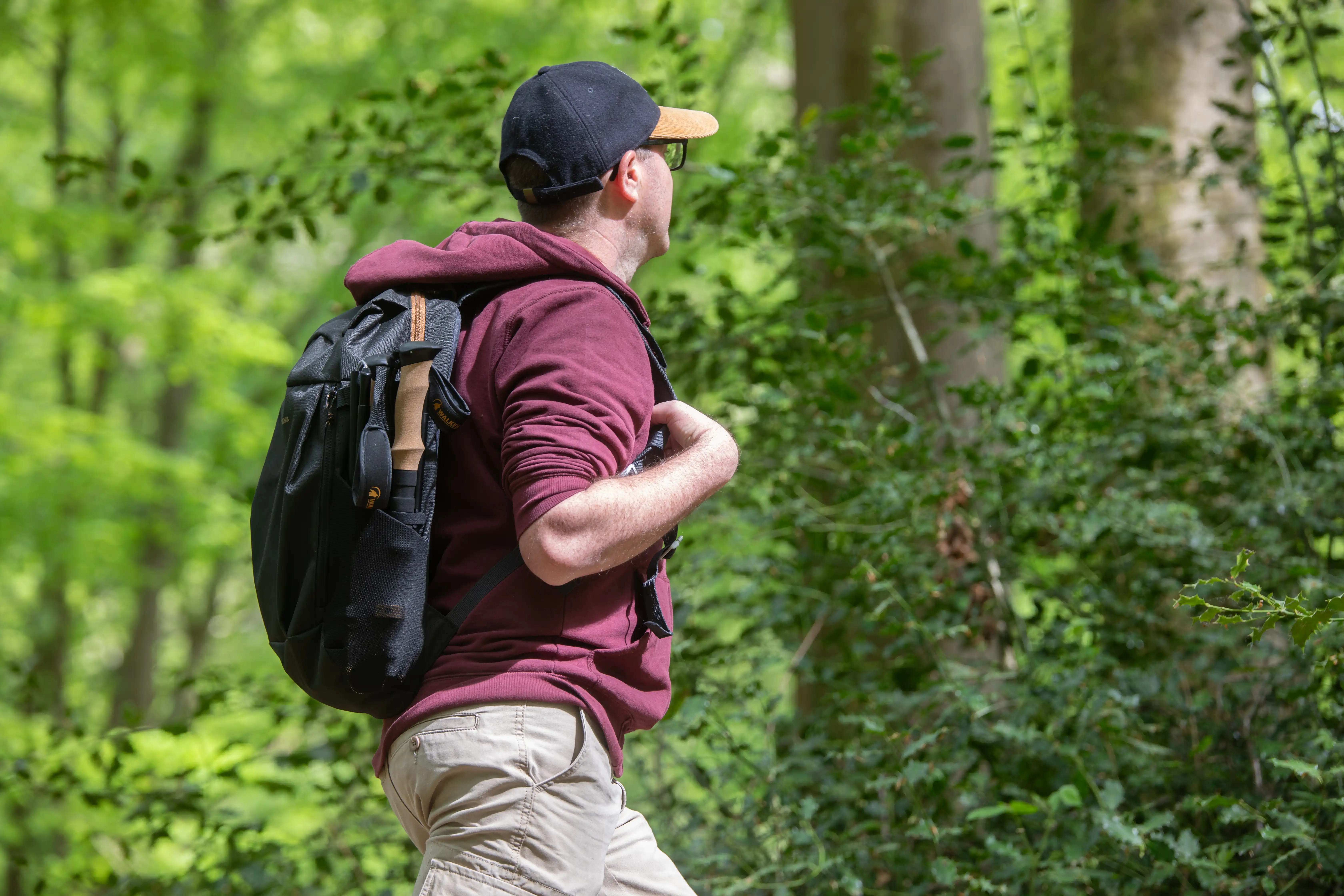 Marcheur se promenant avec bâtons de randonnée plié et ranger dans son sac